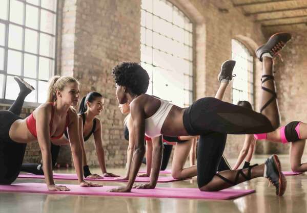 一位成年人在家铺着瑜伽垫，做轻柔的伸展动作，空间安静明亮